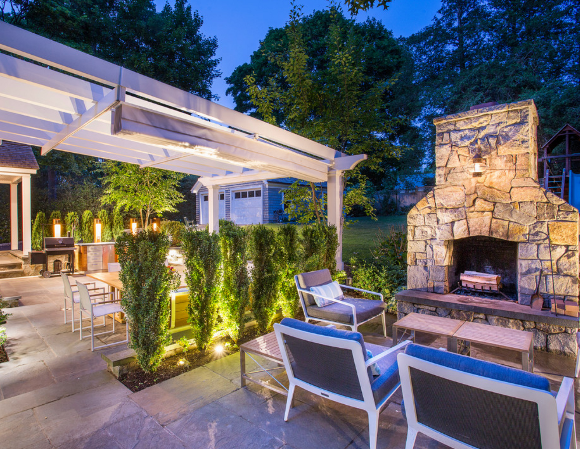 A blue truck is parked in front of a large white house