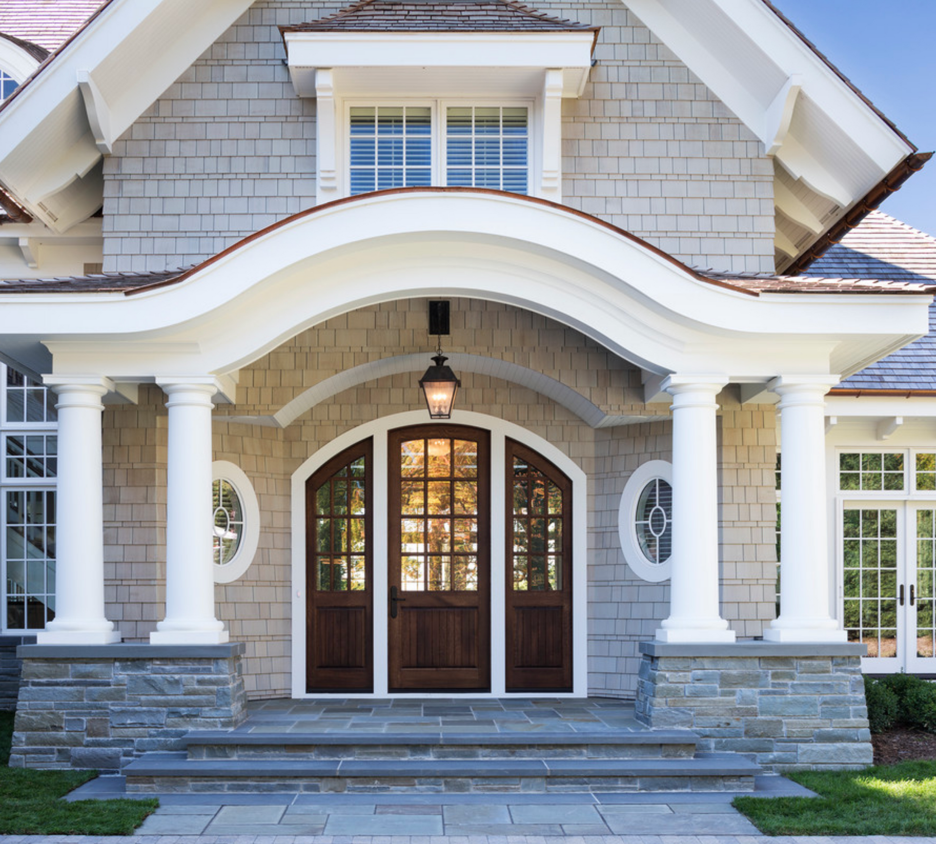 A large house is being built in the middle of a lush green field.