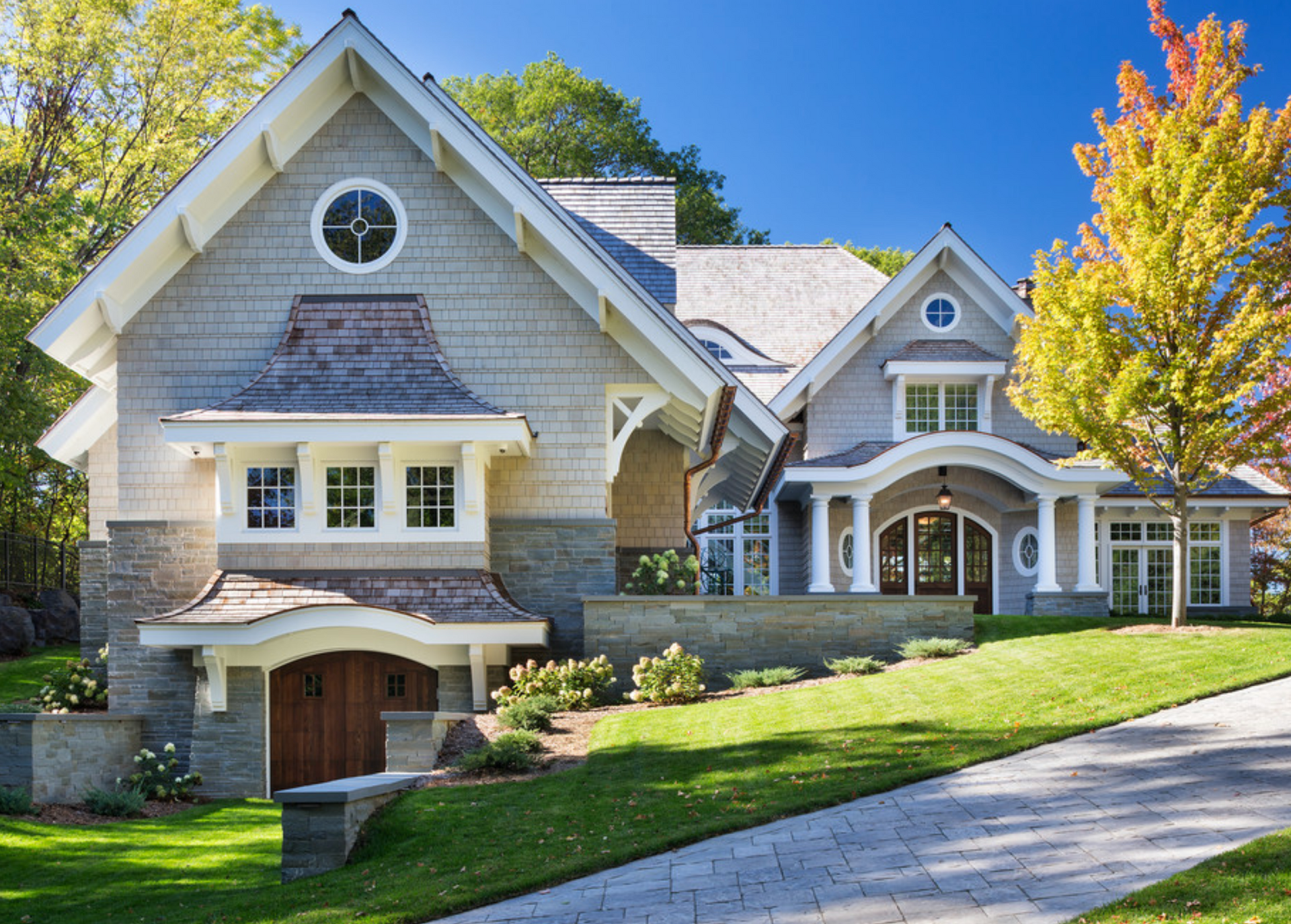 A blue house with a brick walkway leading to the front door.