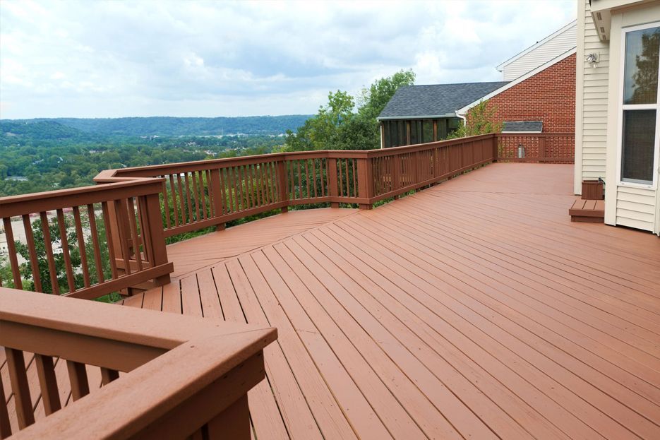 A large wooden deck with a view of a valley
