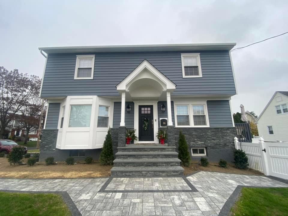 A large house with a porch and stairs in front of it.