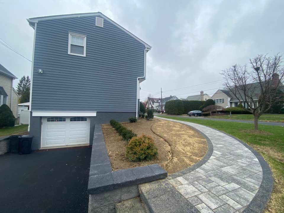 A house with a garage and a sidewalk in front of it.