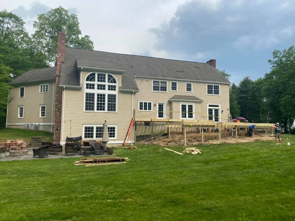 A large house is being built in the middle of a lush green field.