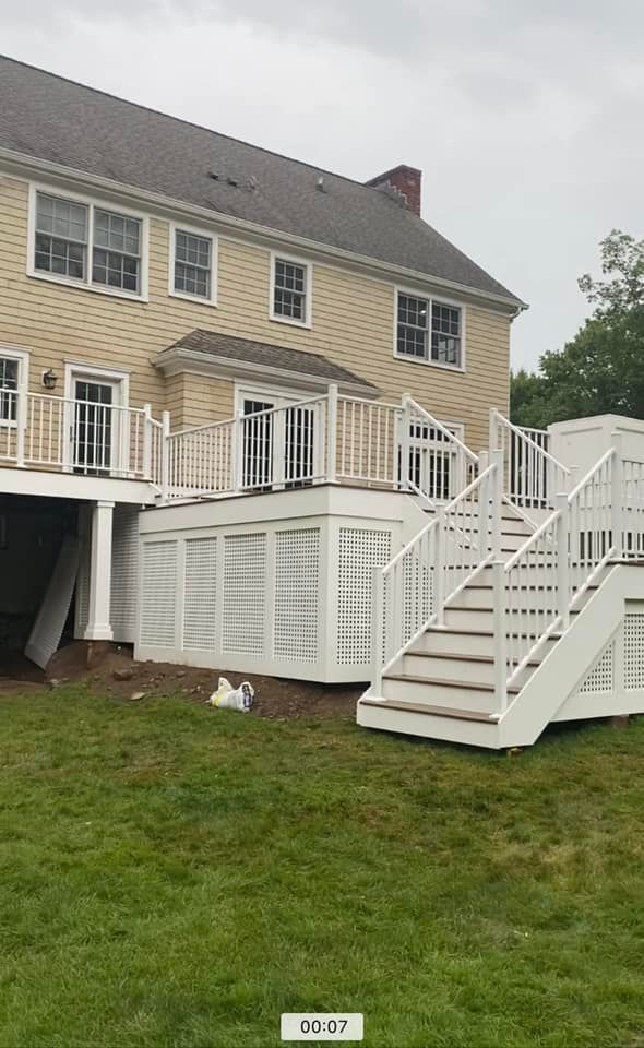 A large house with a large deck and stairs in front of it.