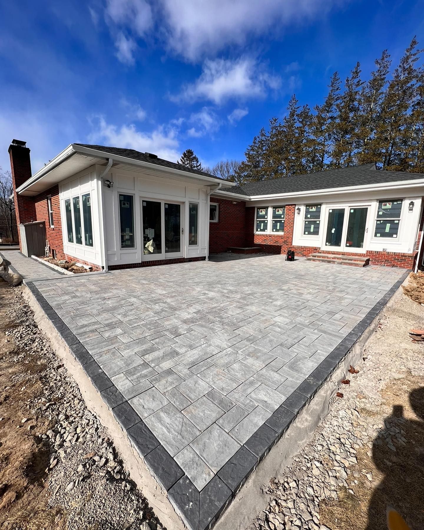 A large brick house with a patio in front of it.