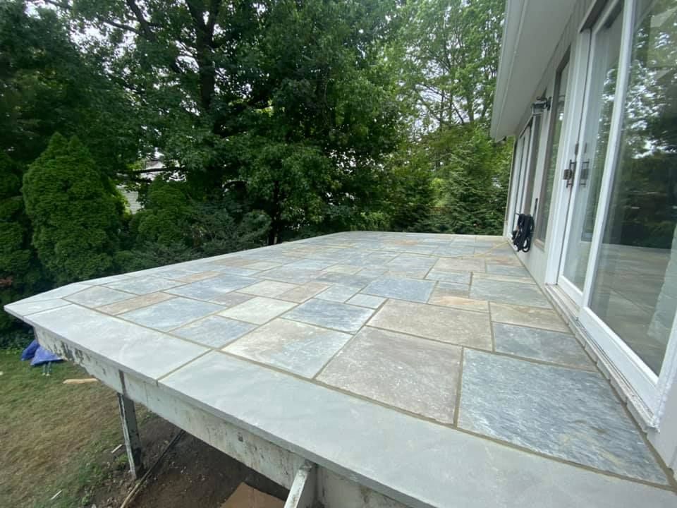 A patio with sliding glass doors is being built on the side of a house.