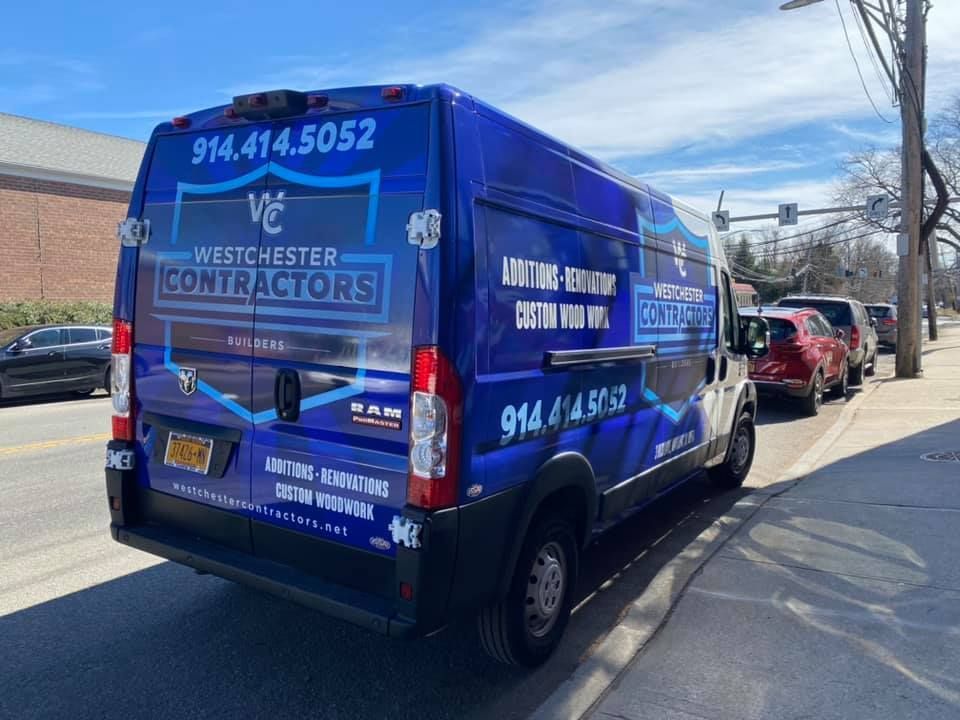 A blue van is parked on the side of the road.