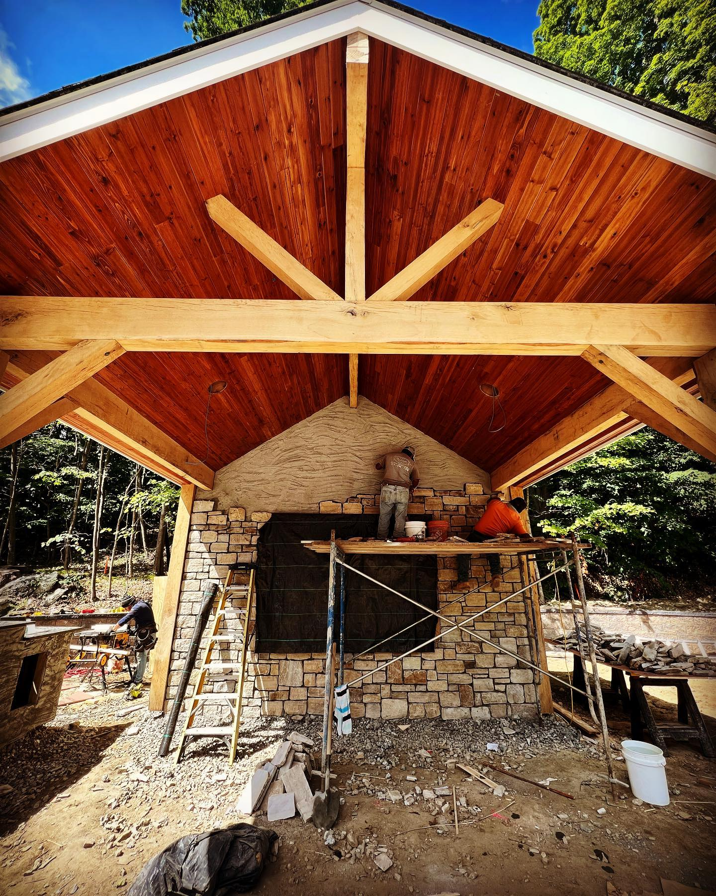 A man is working on the roof of a stone building.