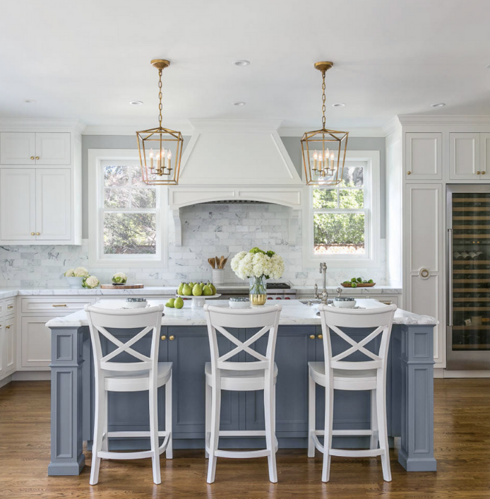 A kitchen with blue cabinets and white stools