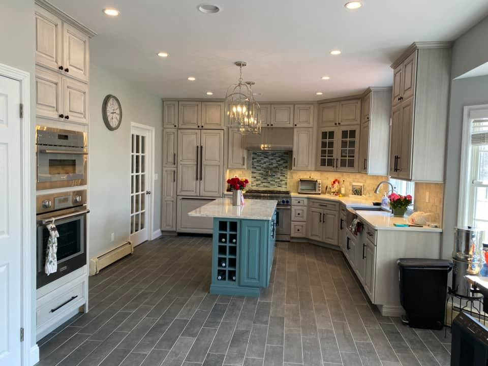 A kitchen with a large island in the middle and a clock on the wall.