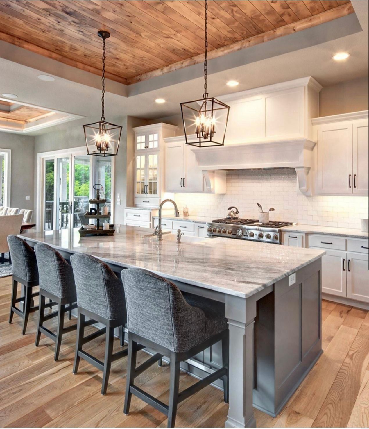 A kitchen with a large island and chairs