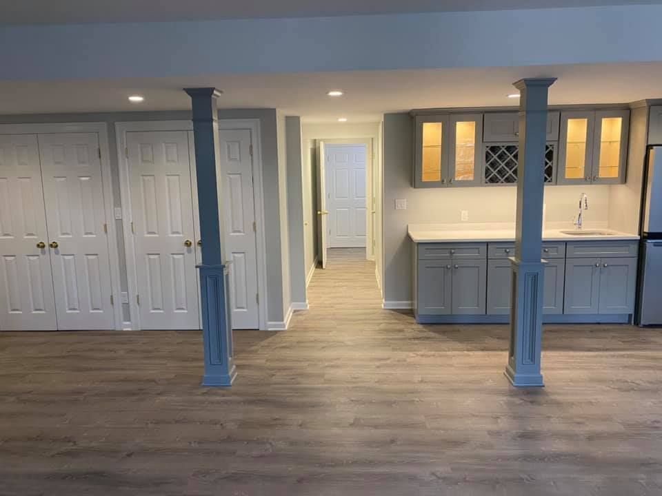 A basement with a kitchen and a bar in it.