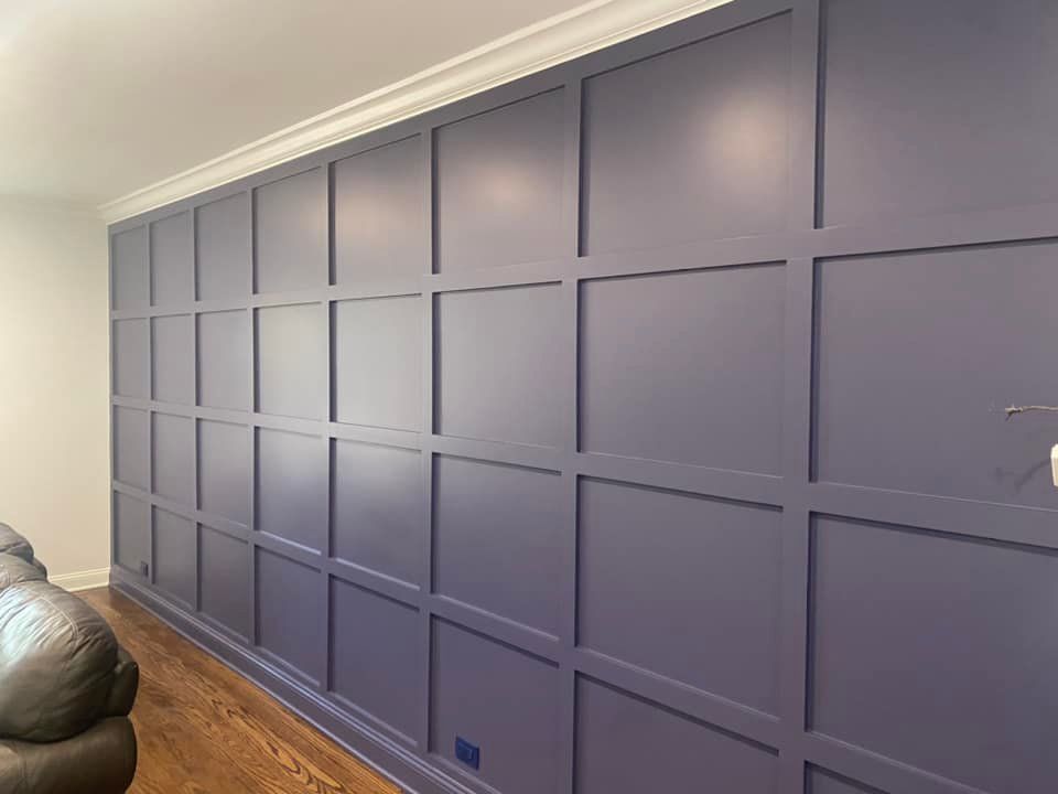 A living room with a purple wall and a couch.