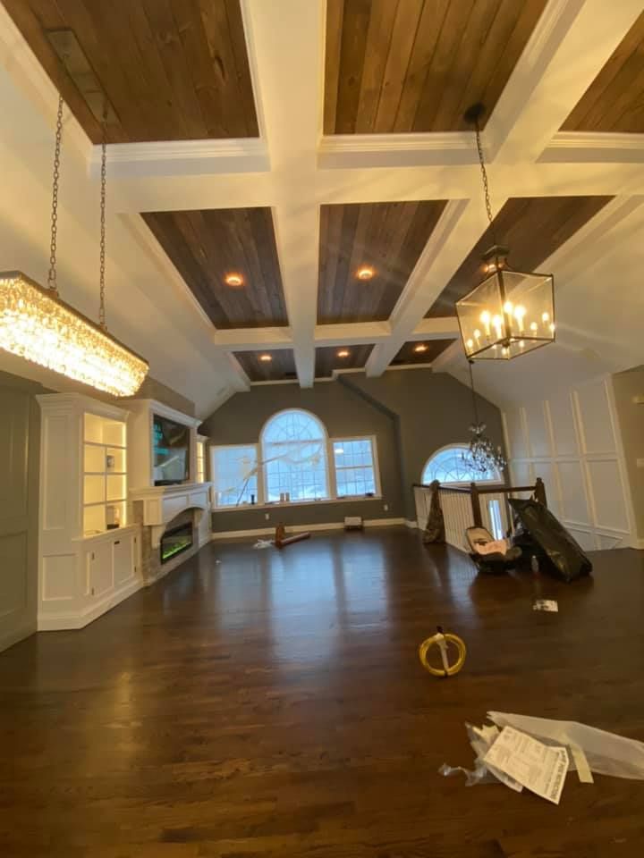 A living room with hardwood floors, a fireplace and a chandelier.