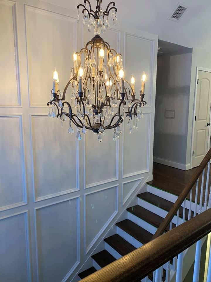 A chandelier is hanging from the ceiling above a set of stairs.