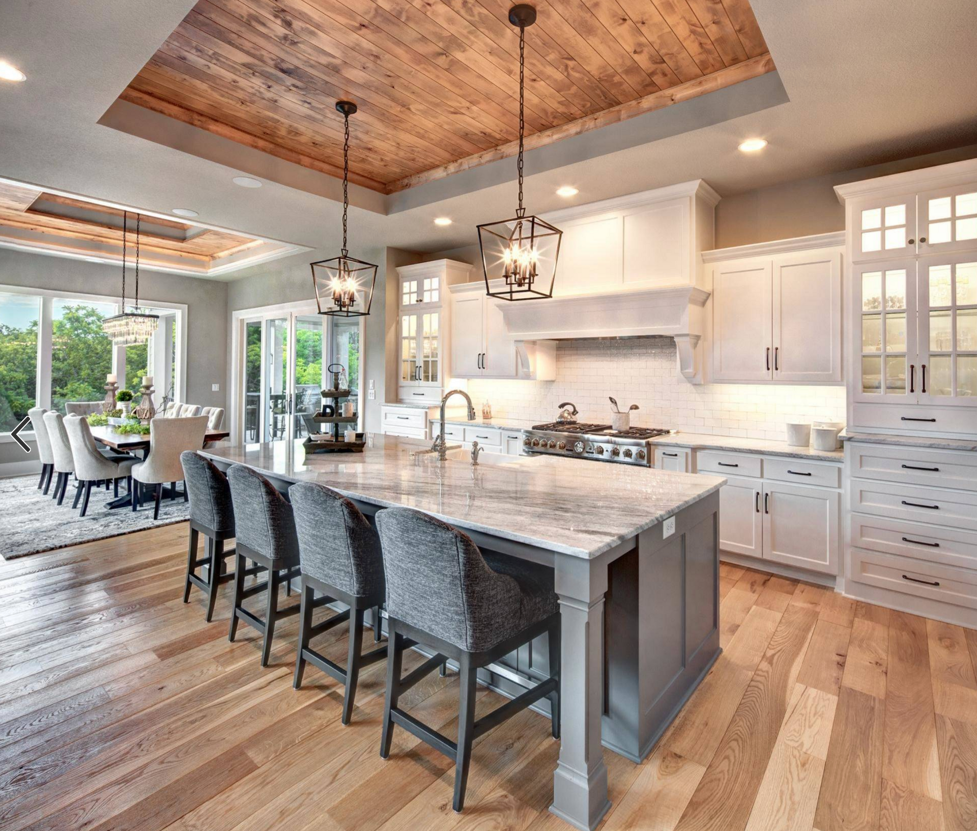 A large house with a large deck and stairs in front of it.