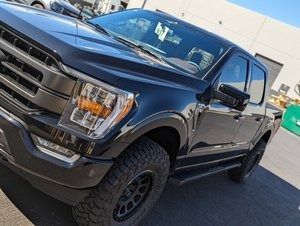 A black pickup truck is parked in front of a building.