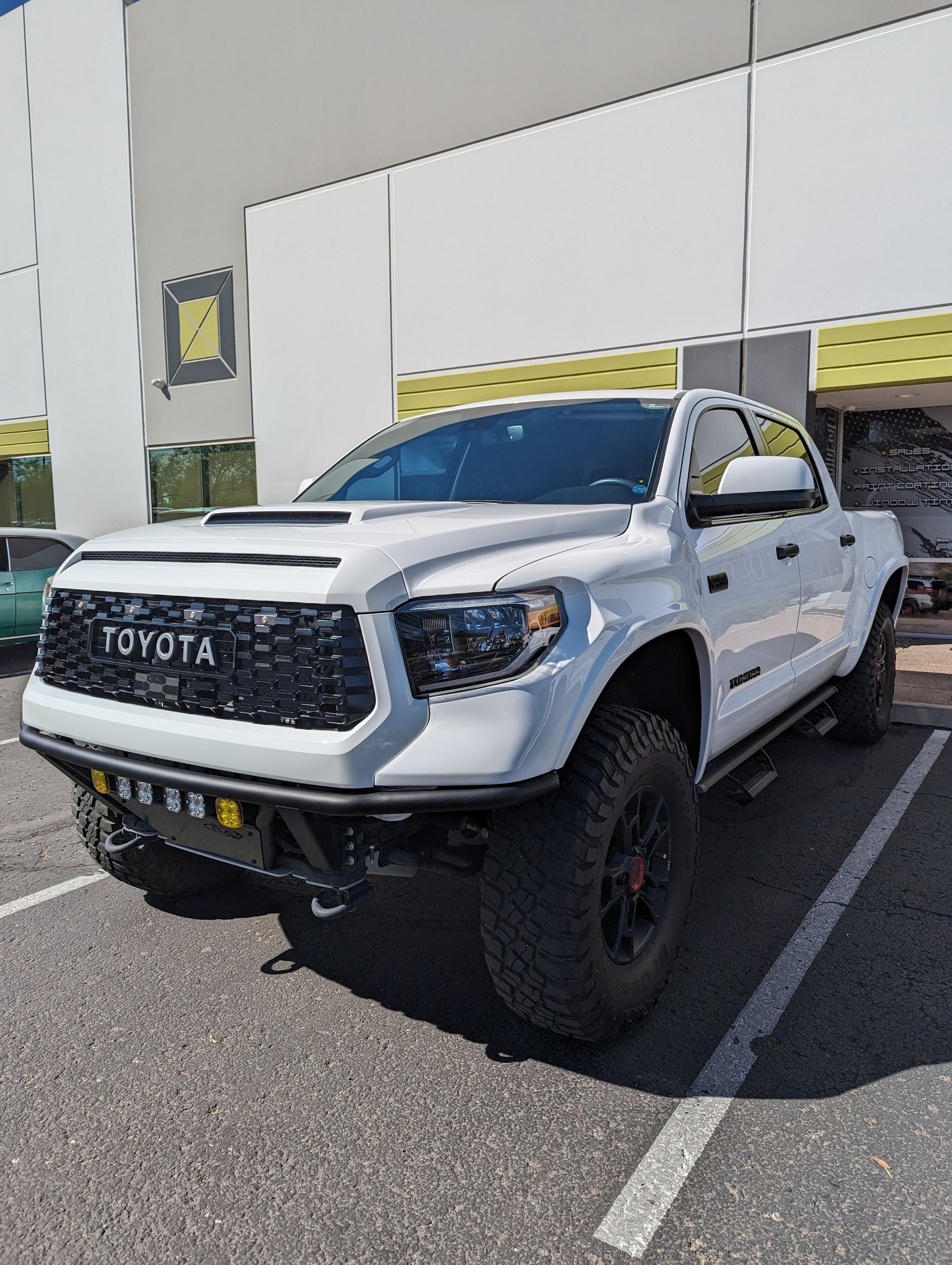A white toyota tundra is parked in a parking lot.