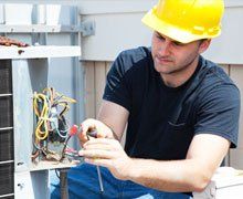 repairman fixing an air conditioning compressor