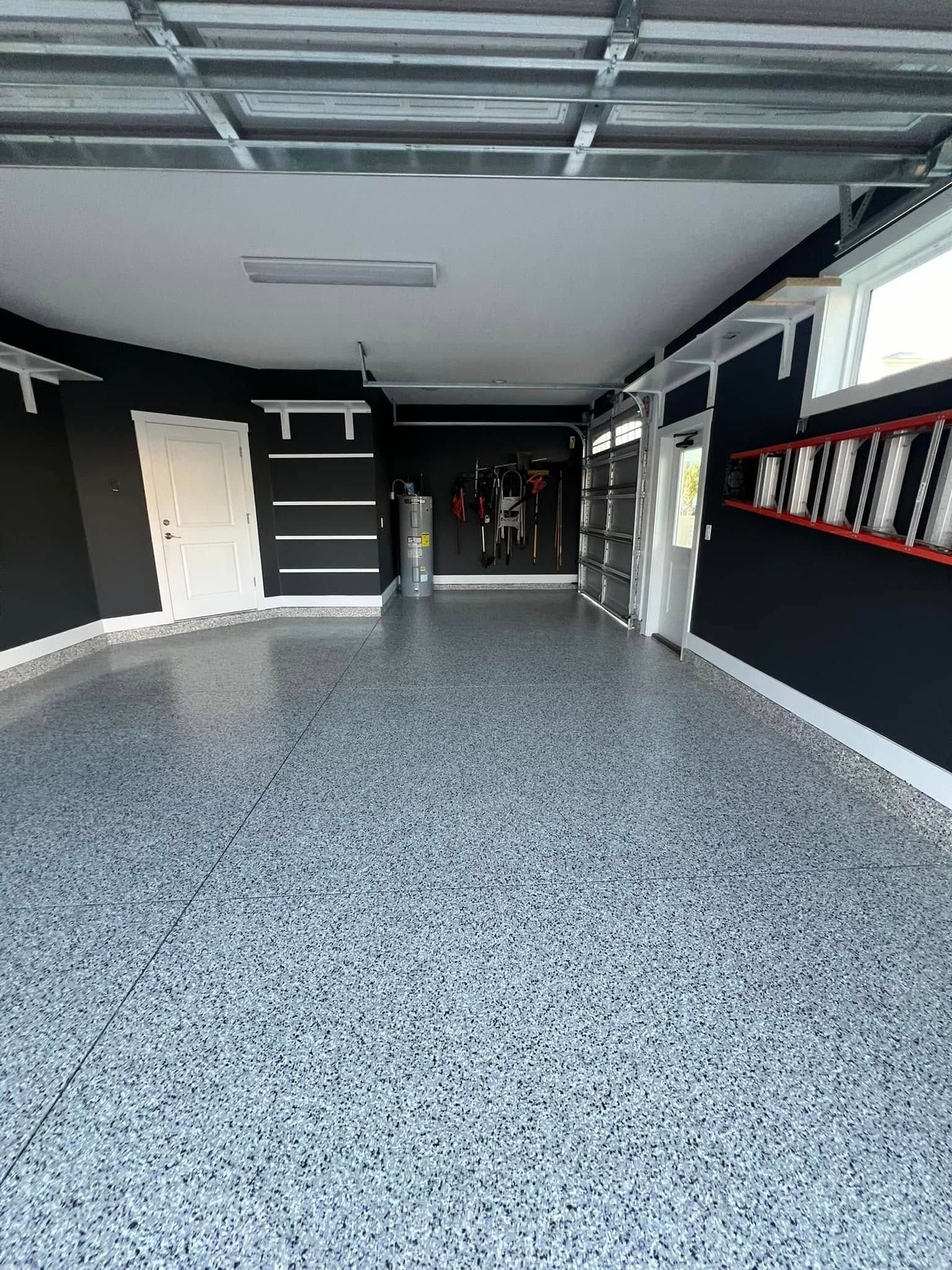Garage interior with speckled gray floor, black walls, and white trim.