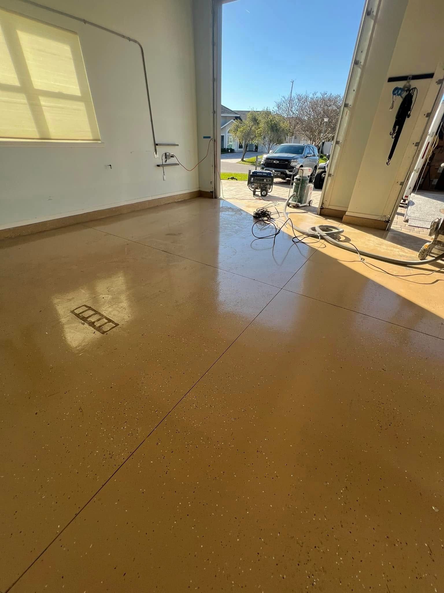 Tan epoxy garage floor with slight reflection, open doorway.