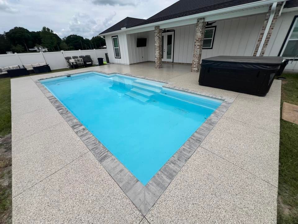 Backyard with rectangular blue pool, gray deck, and black hot tub.
