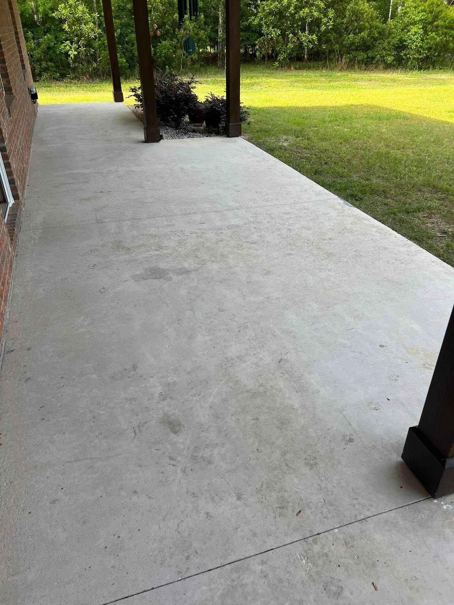 Concrete porch with brick wall and wooden pillars. Green lawn visible in the background.