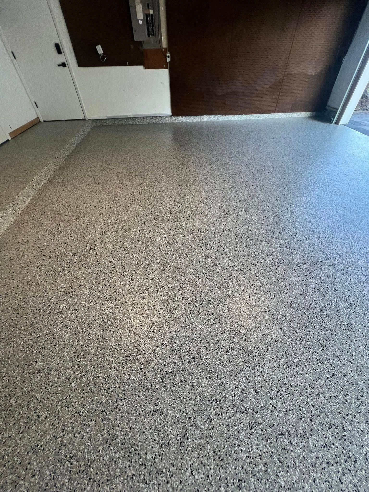 Garage floor with epoxy coating featuring flecks of multiple colors.