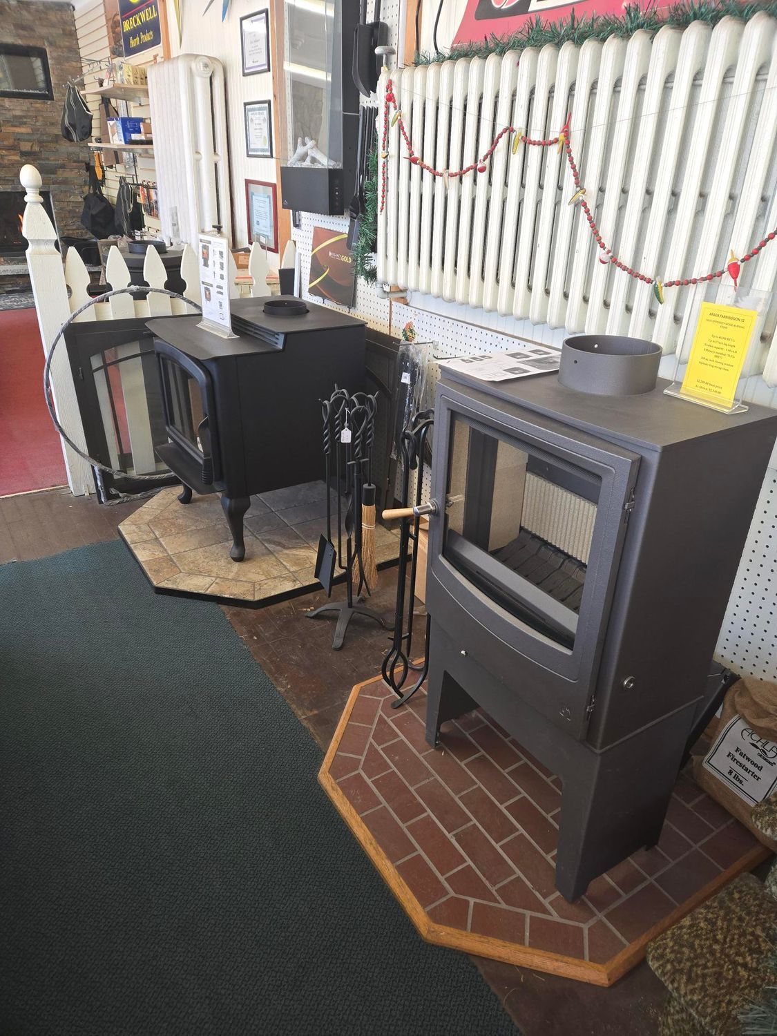 Black wood-burning stove on brick hearth in a rustic indoor shop display