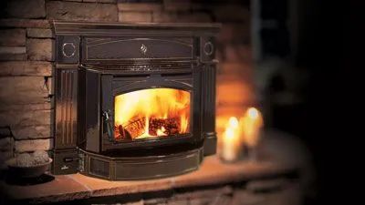 A fireplace with a wood stove and candles in it.