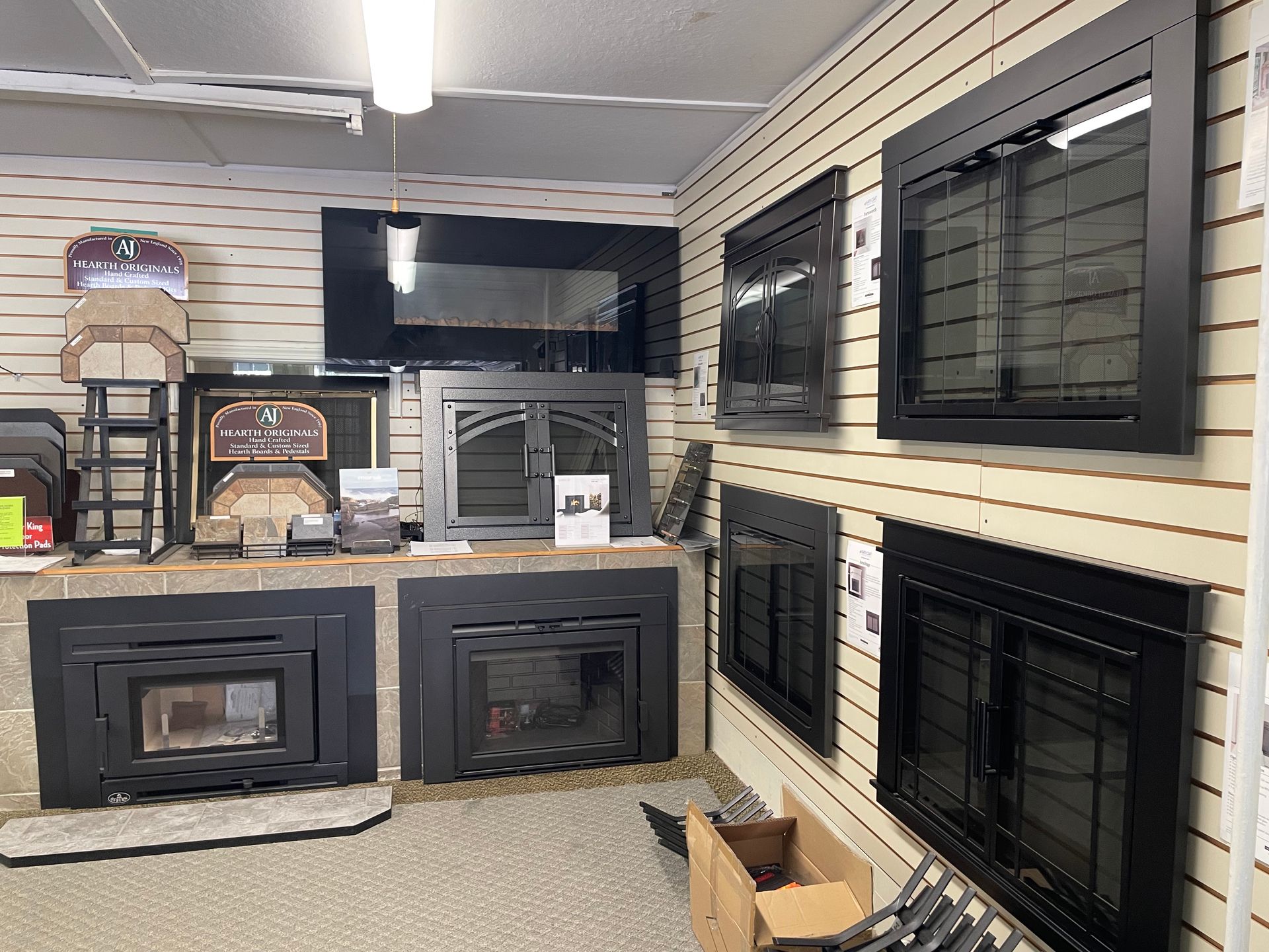 A room with a lot of fireplace inserts on display.