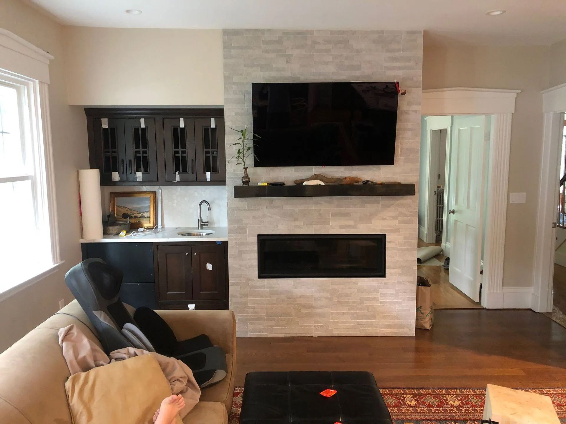 A living room with a fireplace and a flat screen tv on the wall.