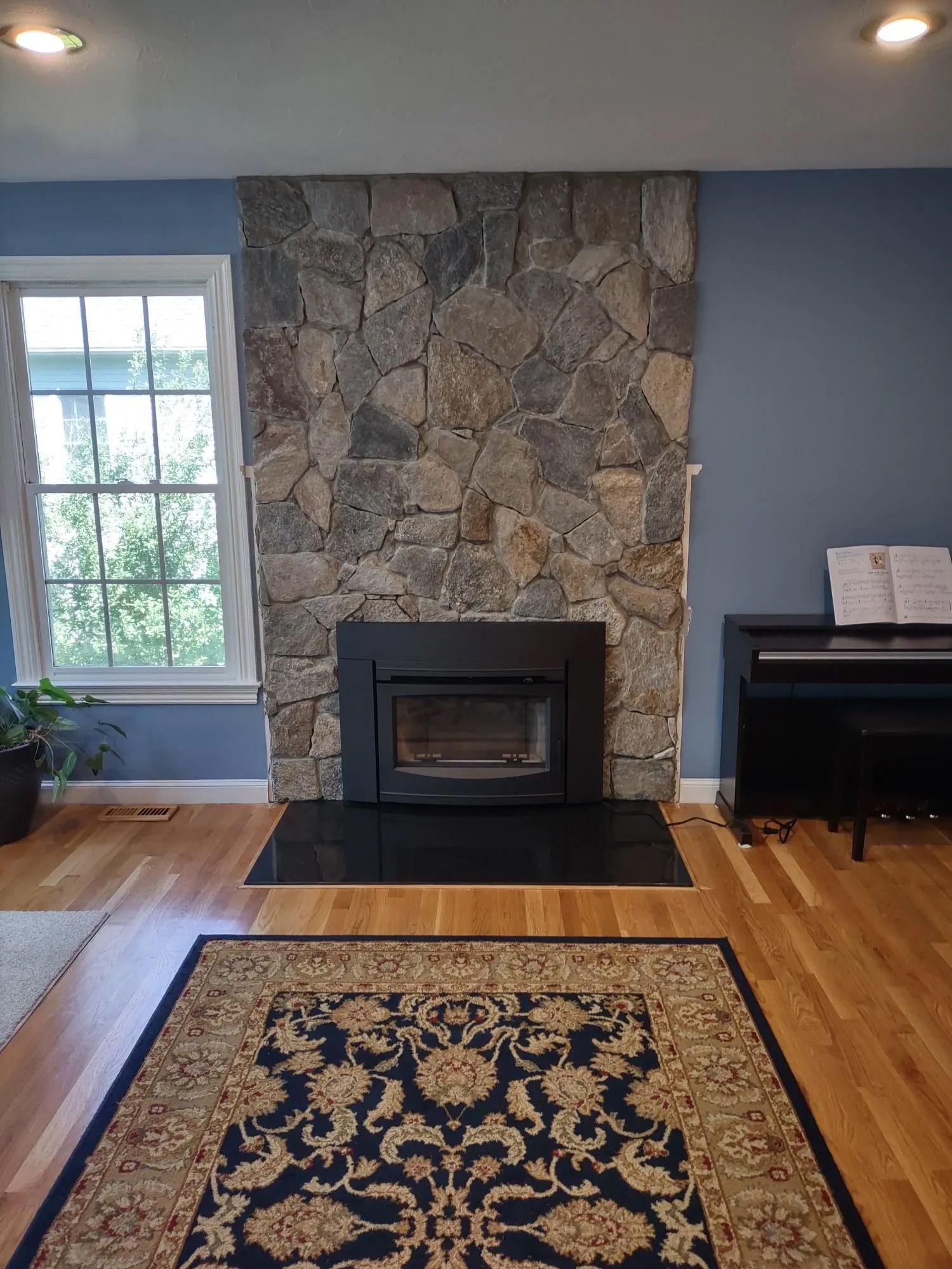 A living room with a fireplace and a piano.