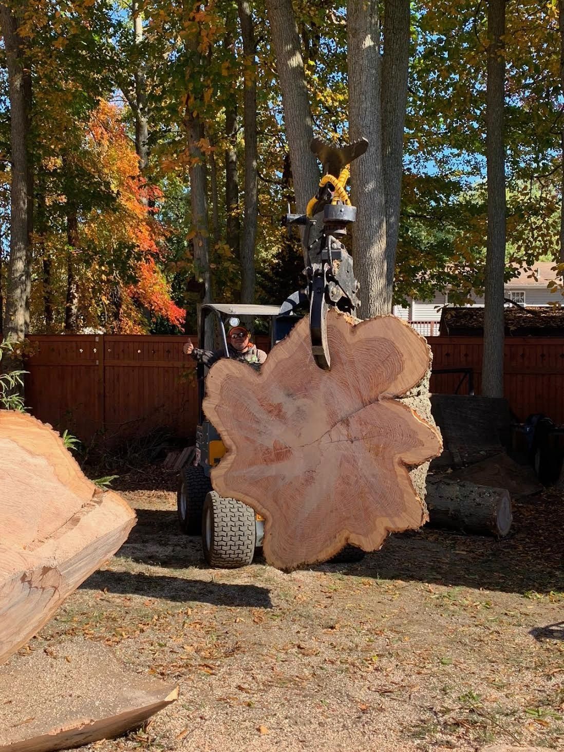 A large piece of wood is being lifted by a forklift.