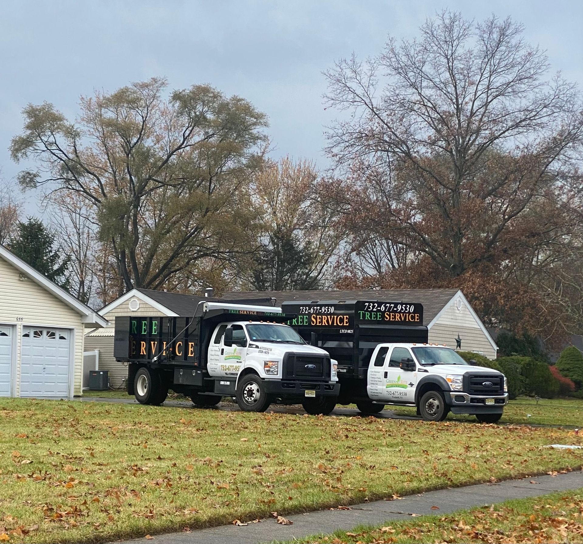 Two trucks are parked in a grassy field 