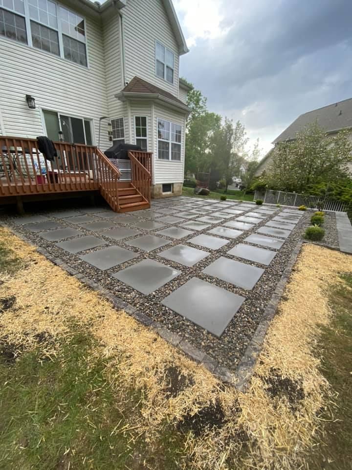 A patio with a deck and stairs in front of a house