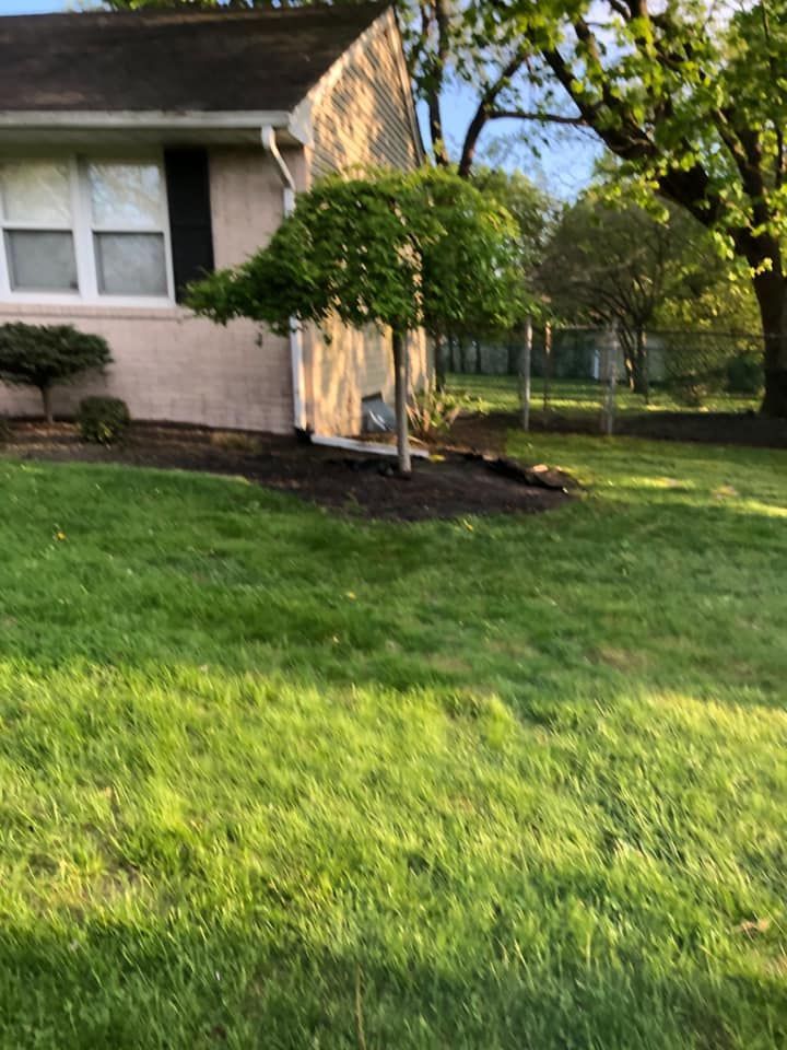 A house with a lush green lawn in front of it.