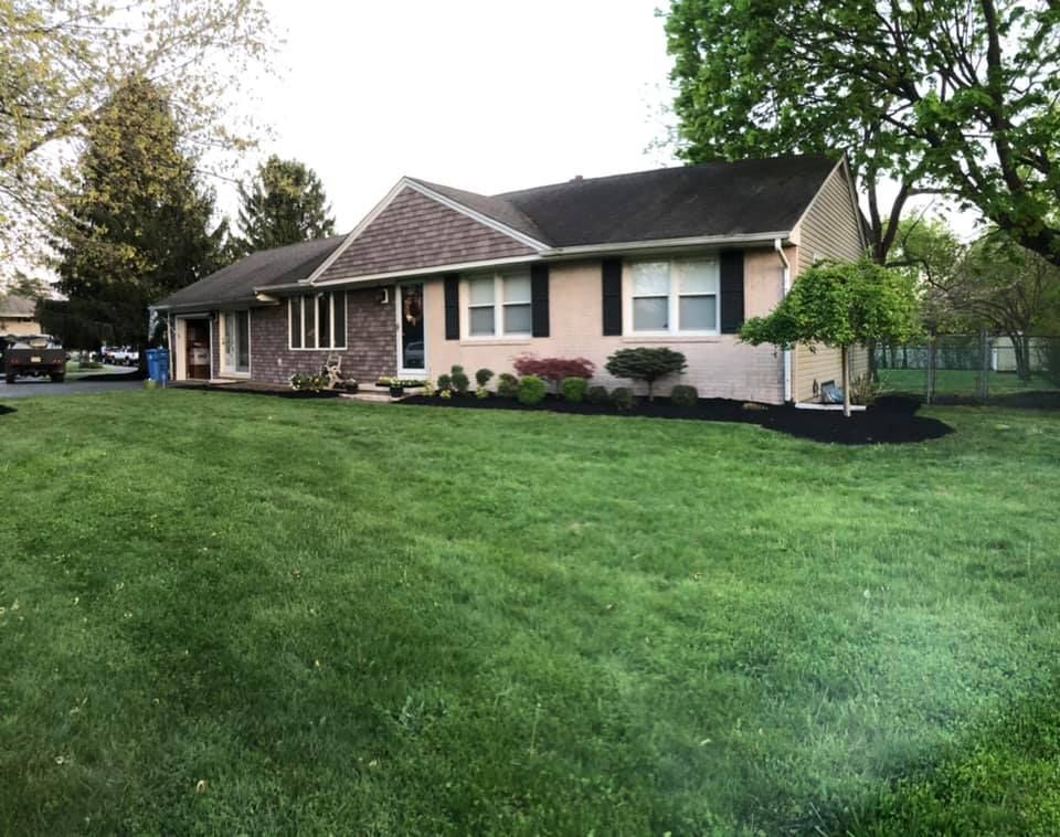 A house with a lush green lawn in front of it