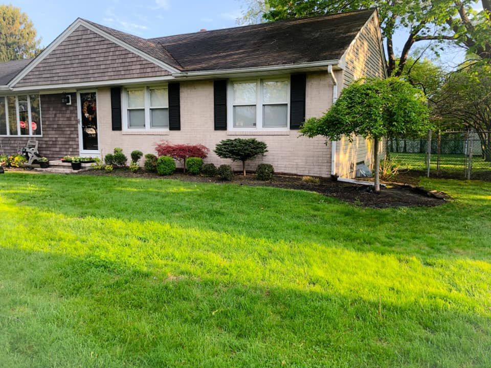 A house with a lush green lawn in front of it.