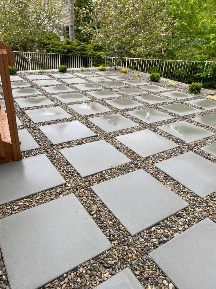 A patio with a bench and a fence in the background