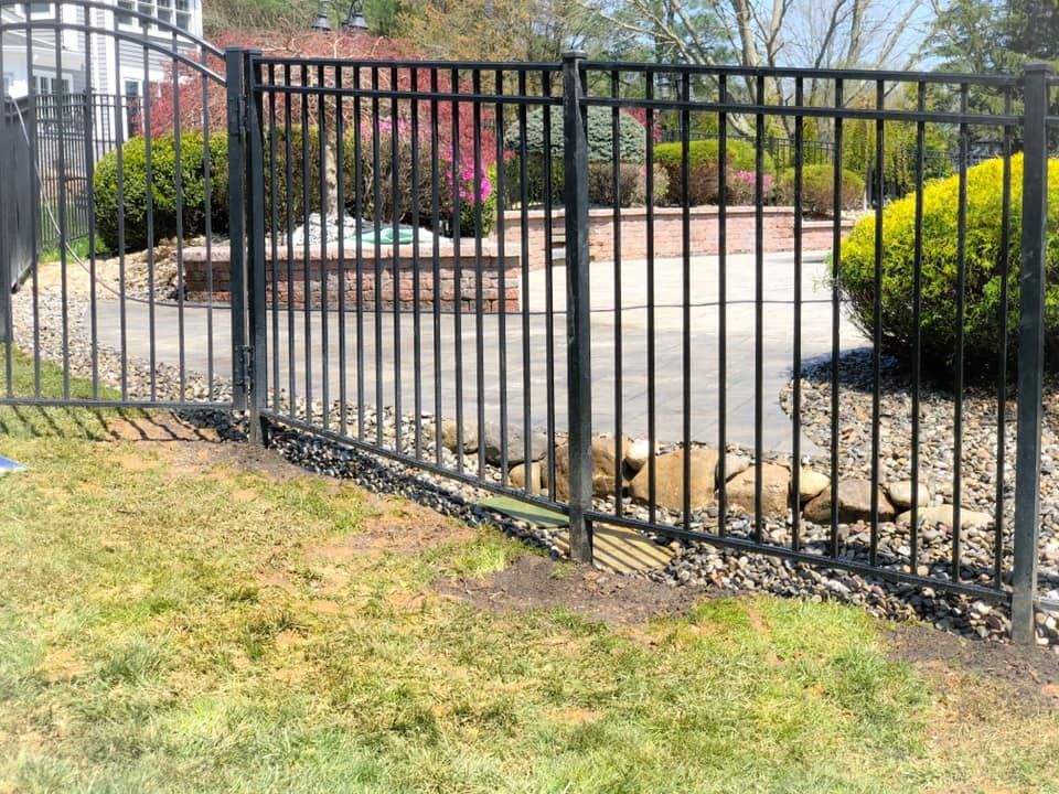 A black metal fence surrounds a swimming pool
