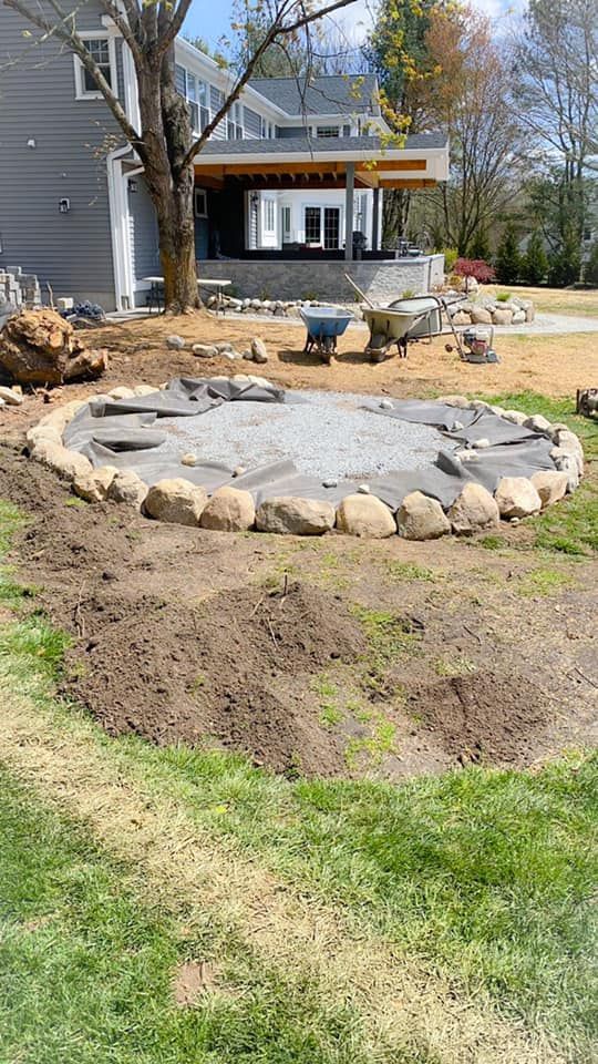 A fire pit is being built in the backyard of a house