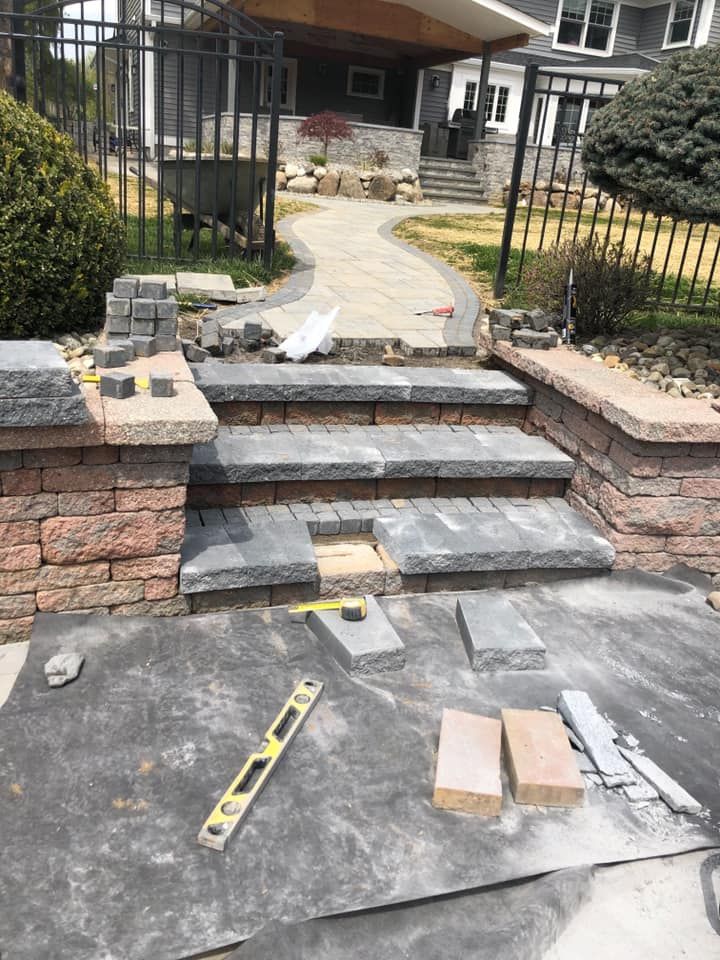 A brick walkway is being built in front of a house