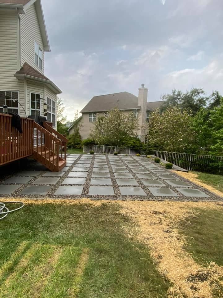 A patio with a deck in the backyard of a house.