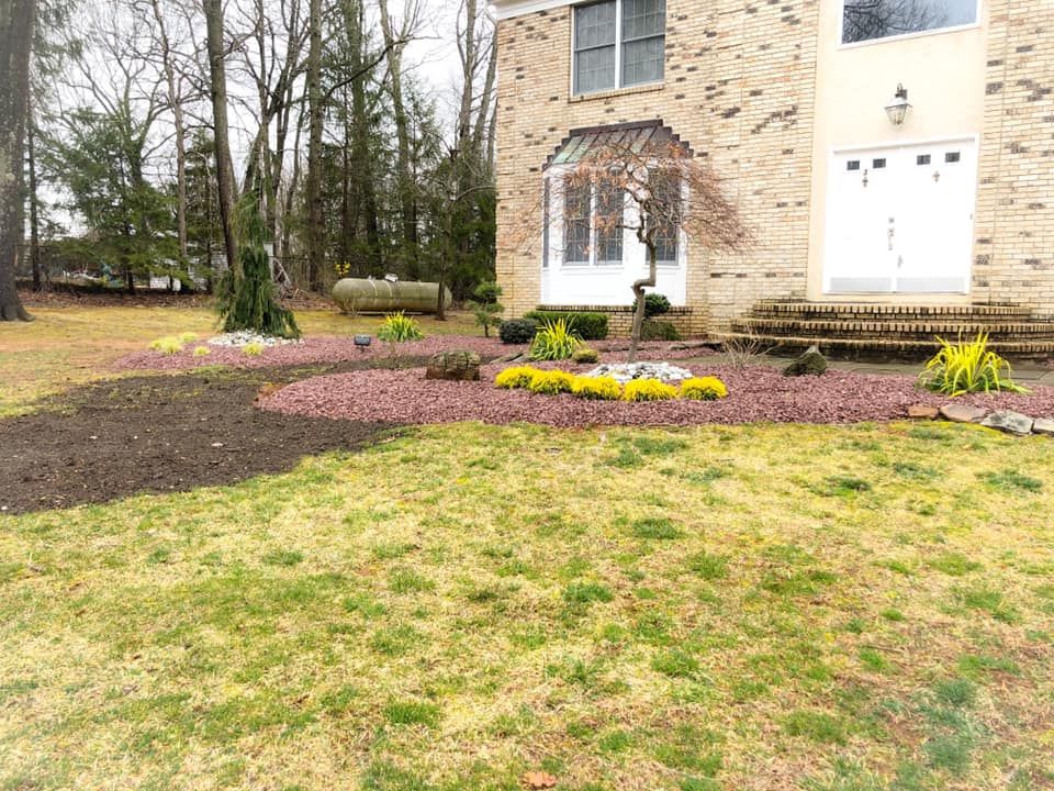 A large brick house with a lush green lawn in front of it