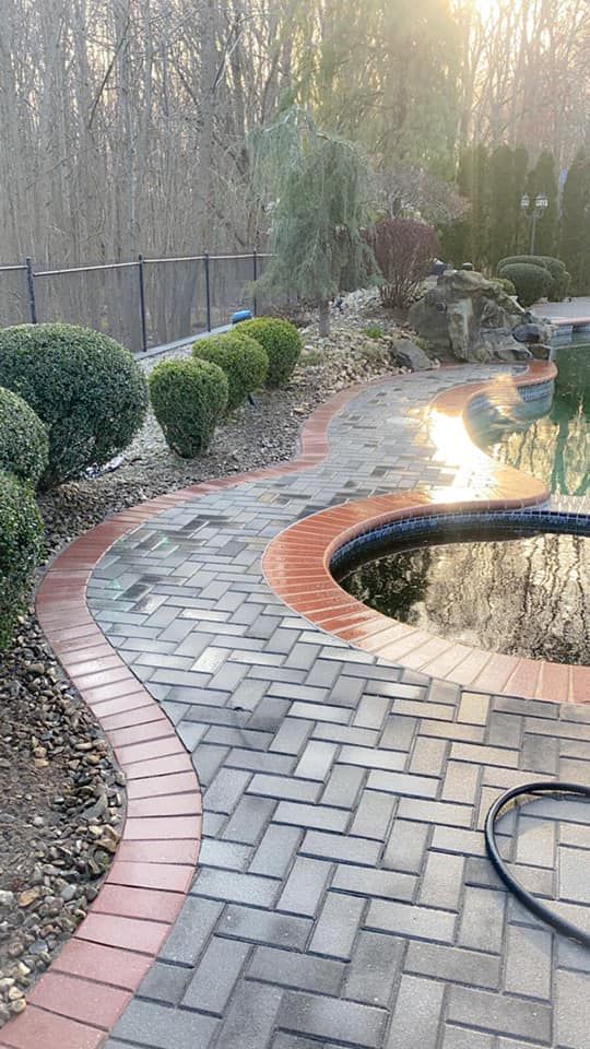 A brick walkway leads to a  backyard