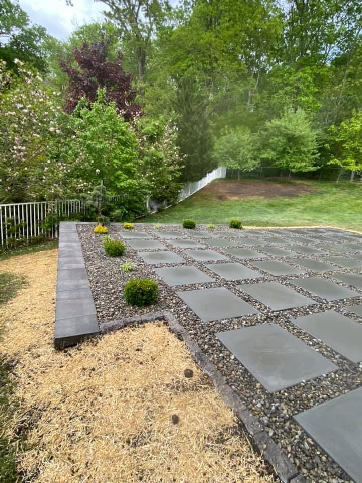 A patio with a fence and trees in the background