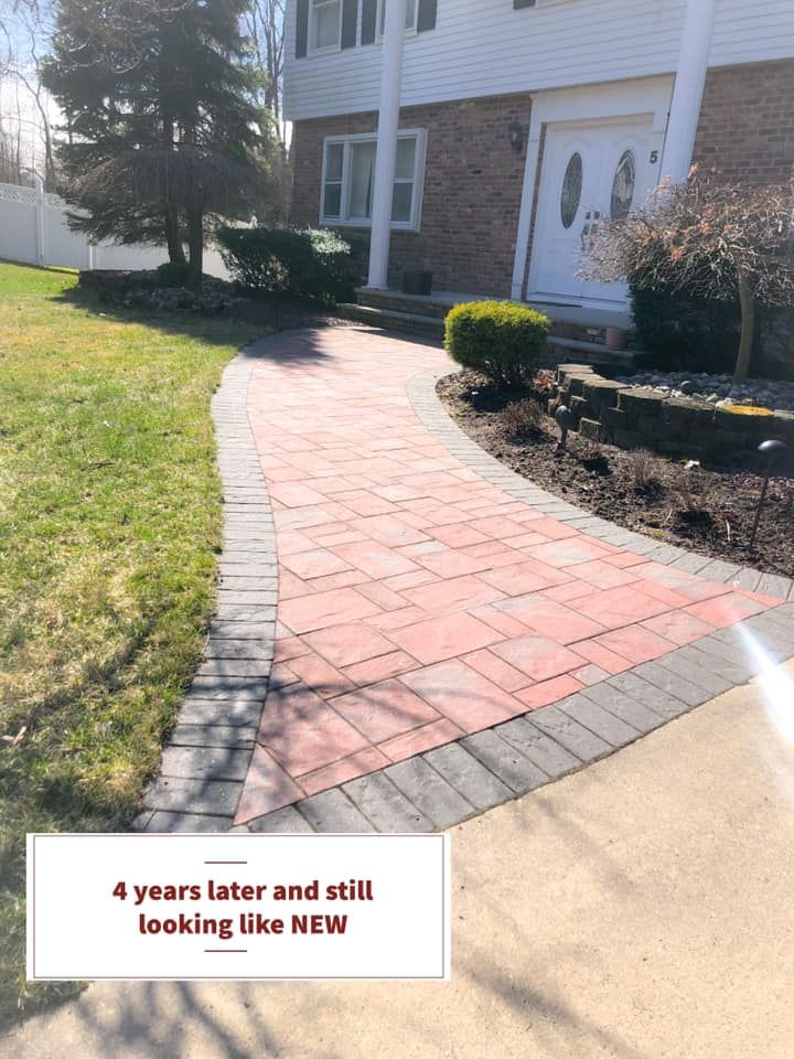 A brick walkway leading to a house and still looking like new