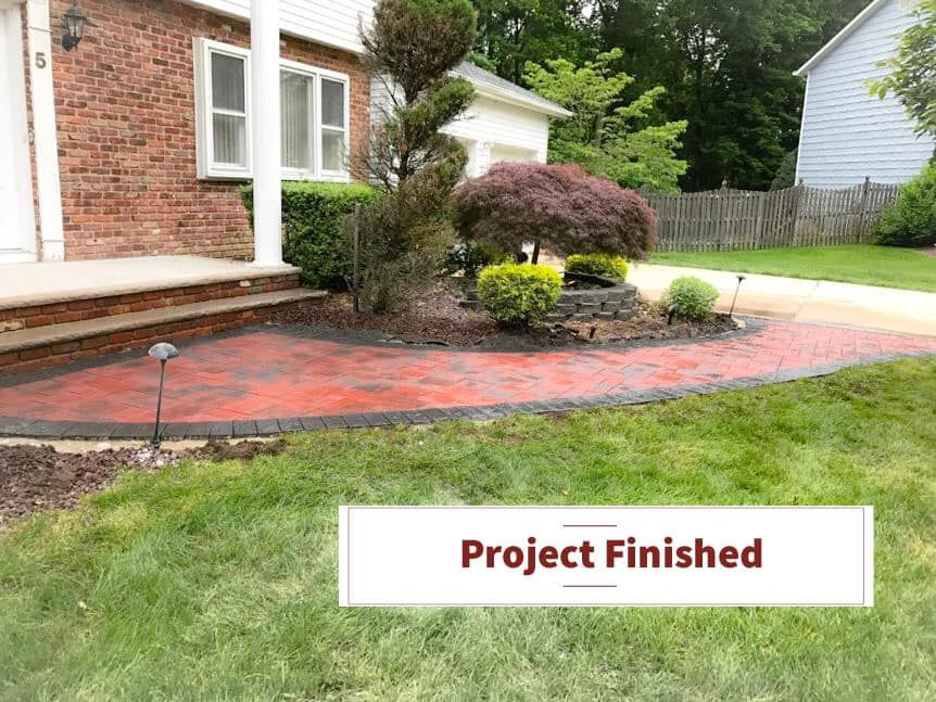 A picture of a brick walkway in front of a house that has been finished