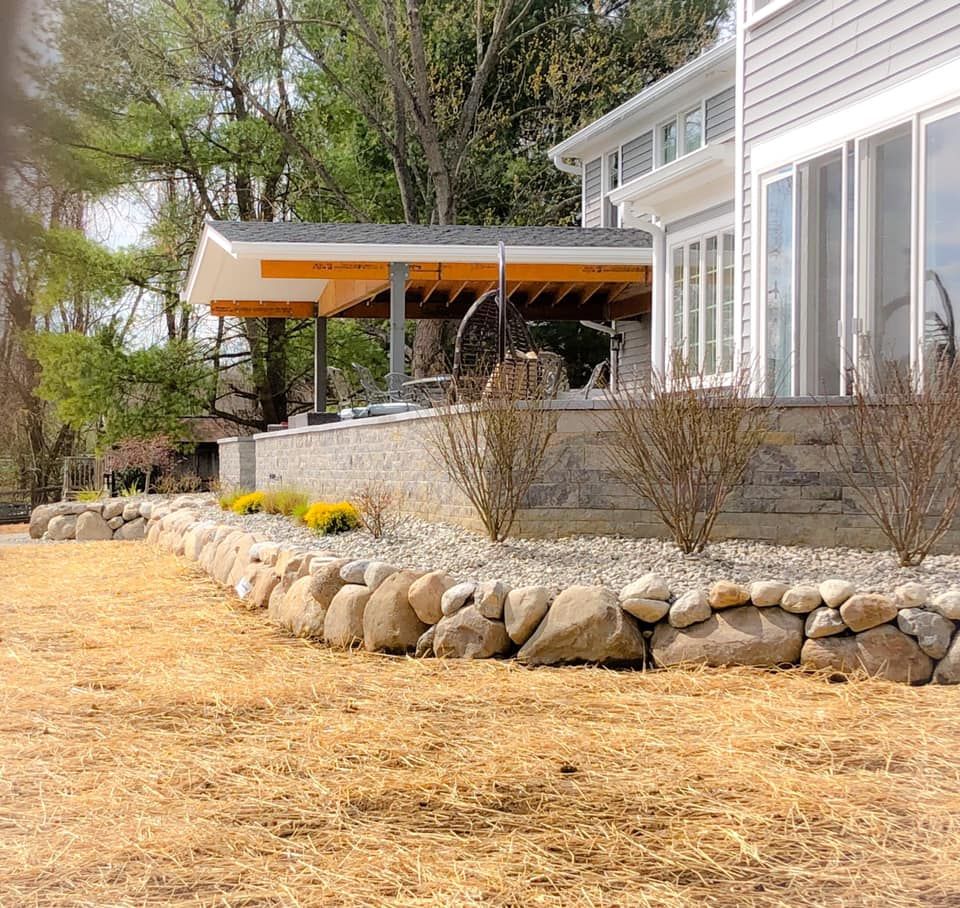 A house with a lot of windows and a stone wall